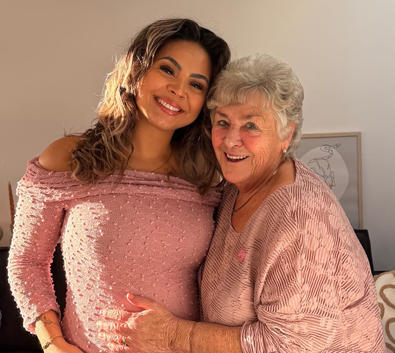 Michelle in a rose dress, laughing with her grandmother