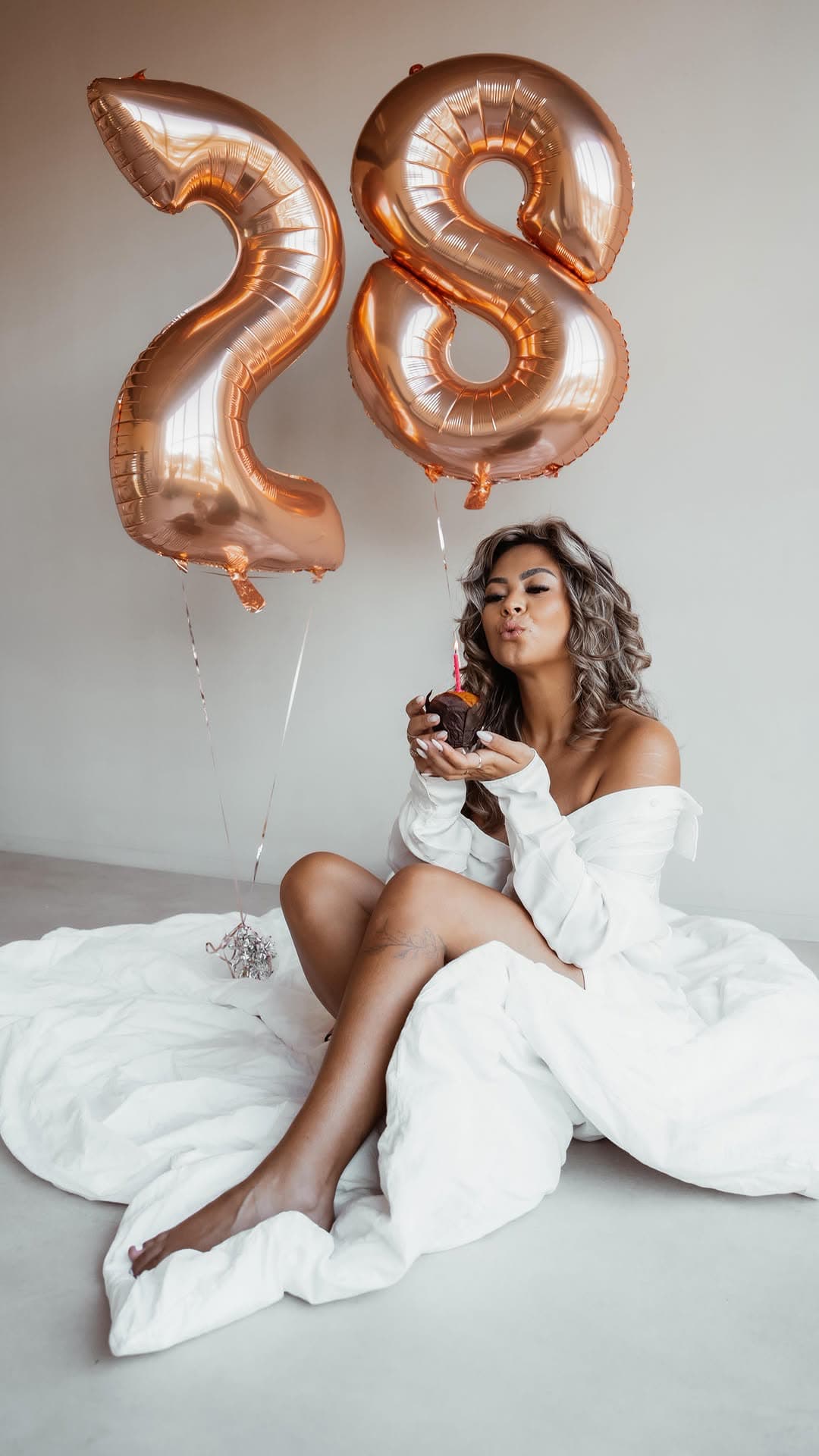 Michelle with balloons on a white bed